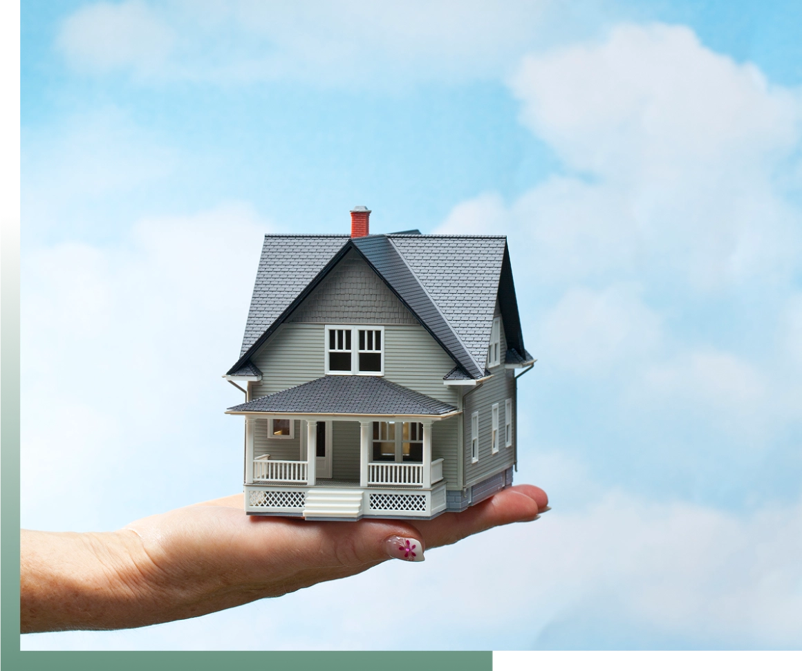 Hand holding miniature house model