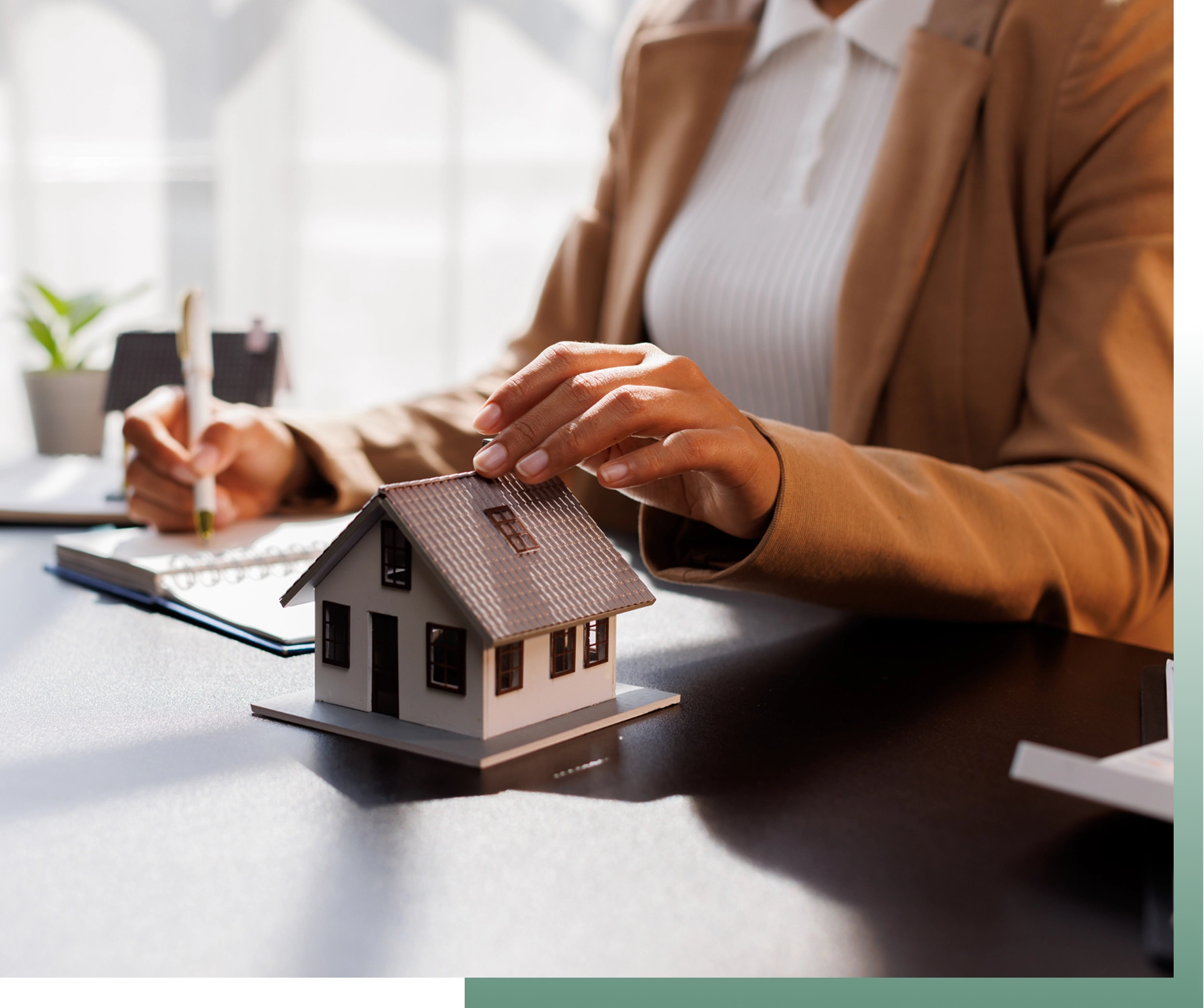Businesswoman writing near miniature house