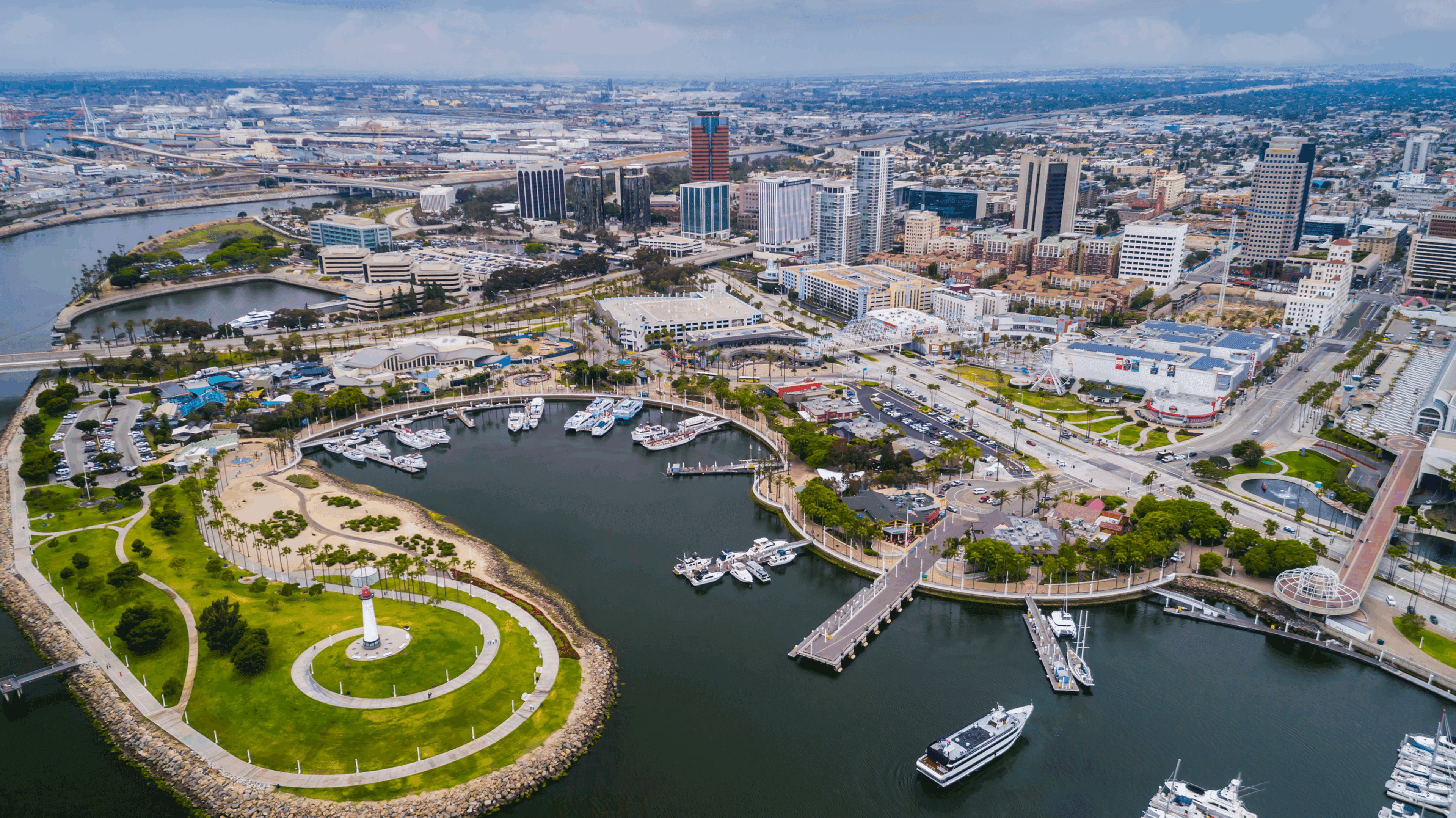 Aerial view of a waterfront city with boats and a circular park.