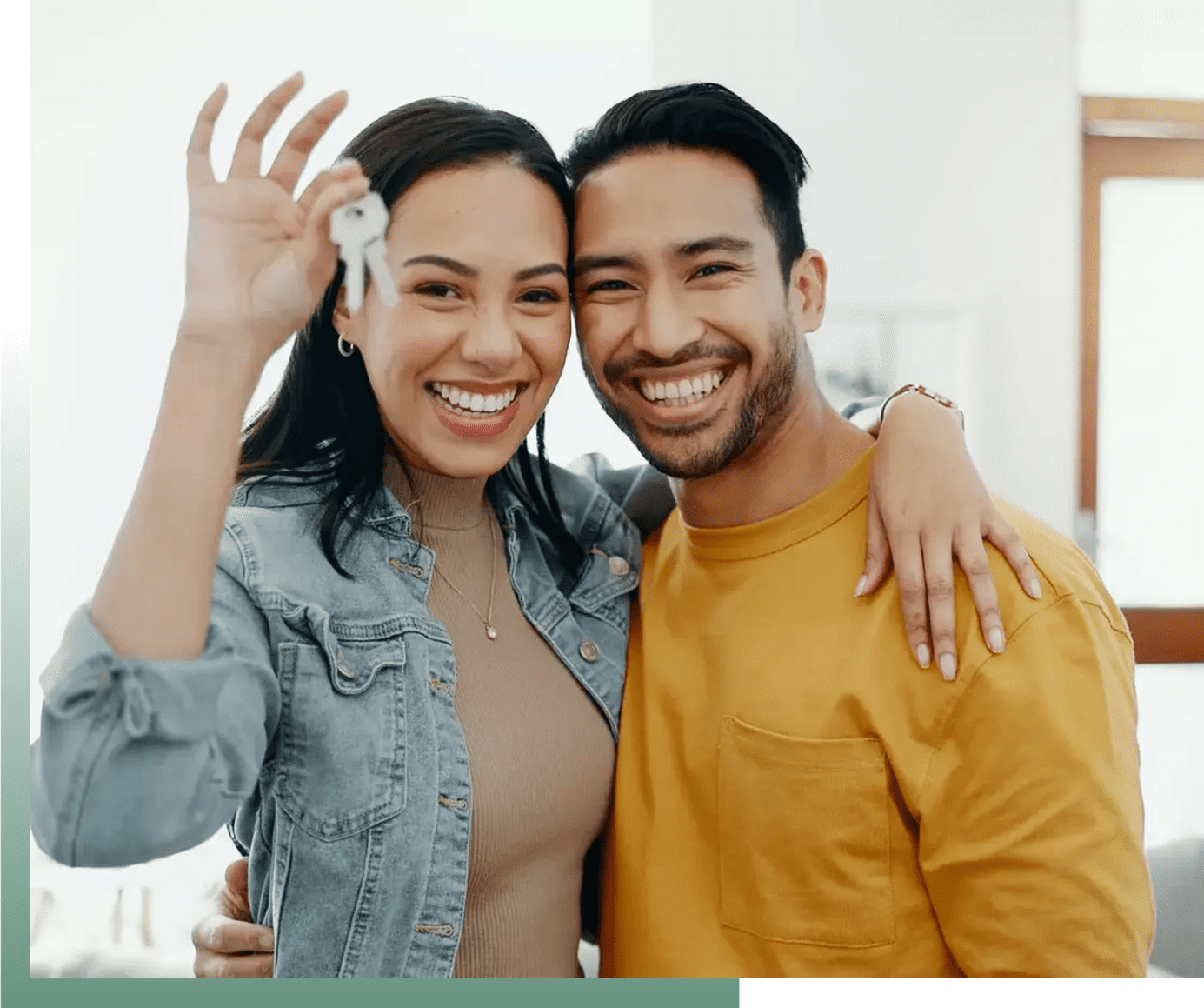 Happy couple holding house keys, smiling at the camera.